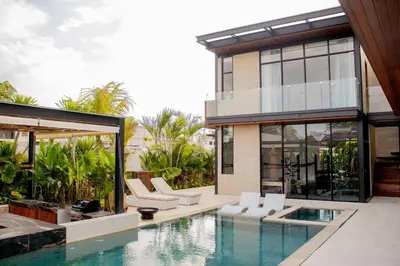 a house with a swimming pool next to a house at Luxury Villa Gym Pool and Gazebo in Canggu