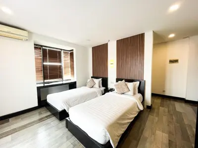 two beds in a room with two windows at Hotel ARA Legian in Legian