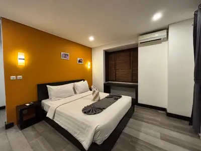 a bedroom with a bed with a yellow wall at Hotel ARA Legian in Legian