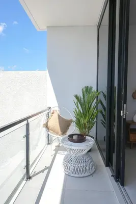 a balcony with a chair and a table at Shanti Villa - 3BR Luxury in Seminyak in Badung