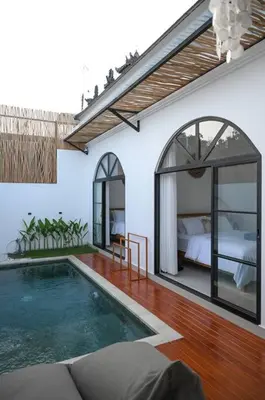 a room with a swimming pool and a bedroom at Eunoia Villa in Jimbaran