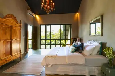 a bedroom with a large bed with a woman sitting on it at Bintarti 3 BR Private Pool Villa in Canggu