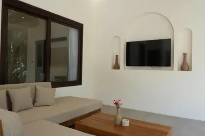 a living room with a couch and a tv at Uma dharma villas in Seminyak