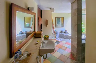 a bathroom with a sink and a large mirror at Vainavi 1 BR Private Pool Villa in Sanur