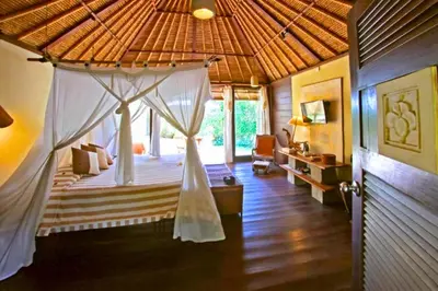 a bedroom with a canopy bed in a house at Vainavi 1 BR Private Pool Villa in Sanur