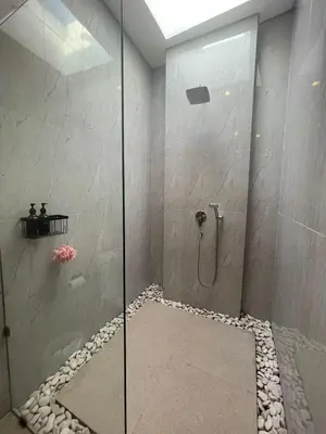 a bathroom with a shower with a glass door at CASA NOOA Kerobokan in Kerobokan