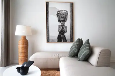 a living room with a couch and a picture on the wall at The Cruise Berawa - Design Apartments & Penthouses by CPM Bali in Canggu