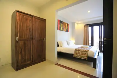a bedroom with a bed and a wooden door at Nyoman Villa Sanur in Sanur