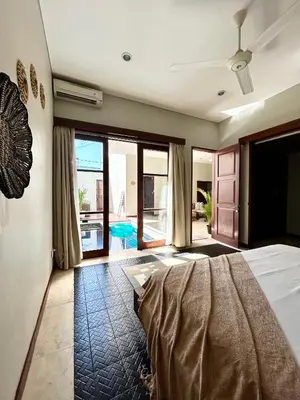 a bedroom with a bed and a view of a pool at MJ Orchid Residence in Seminyak