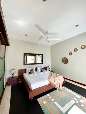 a bedroom with a bed and a ceiling fan at MJ Orchid Residence in Seminyak