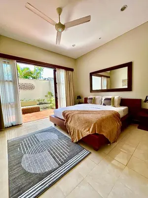 a bedroom with a bed and a large window at MJ Orchid Residence in Seminyak