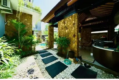 a courtyard of a house with a stone wall at Villa J in Nusa Dua