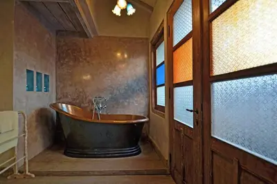 an old tub in a bathroom with a window at Moments Villa in Jimbaran