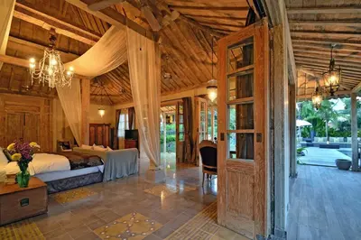 a bedroom with a bed and a chandelier at Moments Villa in Jimbaran