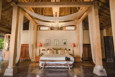 a bedroom with a bed with a large wooden ceiling at Moments Villa in Jimbaran