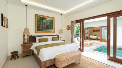 a bedroom with a bed and a swimming pool at Villa Lange 2 by Villa Finder in Seminyak