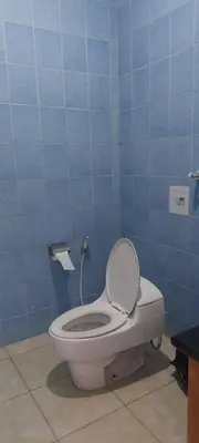 a bathroom with a toilet in a blue wall at Village Pool Private In Kuta Bali in Legian