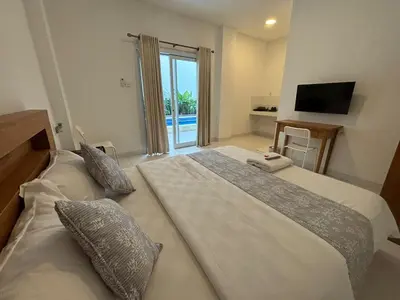 a hotel room with two beds and a television at Jabu Hasian Bali in Kerobokan