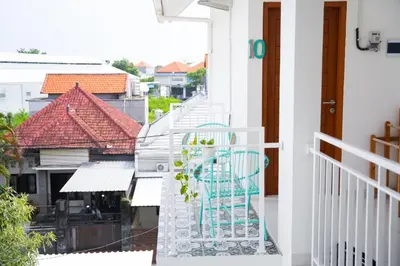 a blue chair sitting on the balcony of a house at Jabu Hasian Bali in Kerobokan