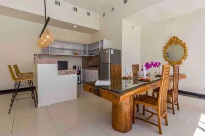 a kitchen with a wooden dining table and chairs at Spacious 2bdr Seminyak walking eat&shop street in Seminyak