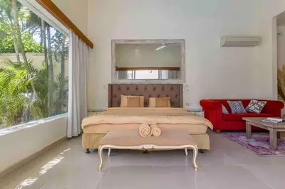 a bedroom with a large bed and a red chair at Spacious 2bdr Seminyak walking eat&shop street in Seminyak