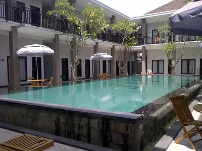 a large pool of green water in a building at Asoka City Bali Hotel in Legian