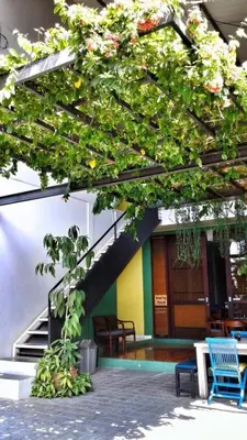a building with a staircase and a table and chairs at Matta Lodge Bali in Jimbaran