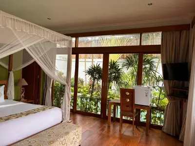 a bedroom with a bed and a balcony with a television at 4 Bedroom Tropical Luxury Villa in Seminyak