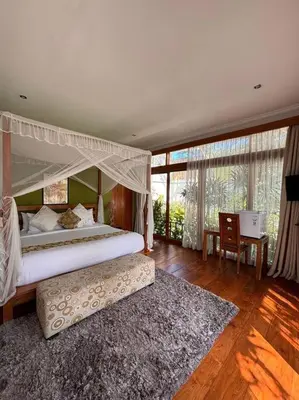 a bedroom with a canopy bed and a rug at 4 Bedroom Tropical Luxury Villa in Seminyak