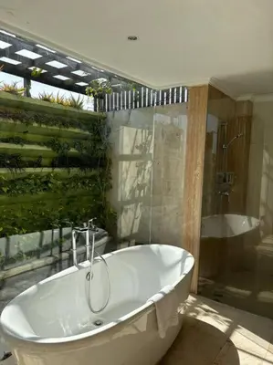 a white bath tub in a bathroom with a shower at 4 Bedroom Tropical Luxury Villa in Seminyak