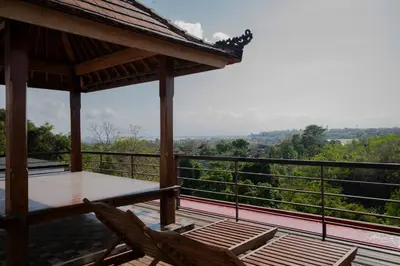 a balcony with two chairs and a view of the forest at Villa with view rooftop in Nusa Dua Bukit in Nusa Dua