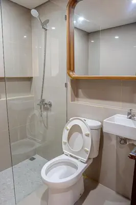 a bathroom with a toilet and a shower and a sink at Green Loft Citarum in Sanur