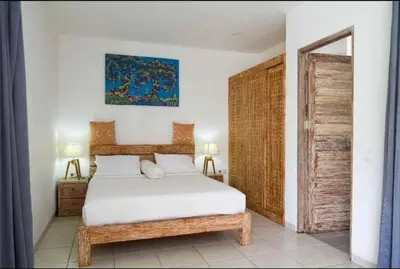 a bedroom with a bed and a wooden door at Villa Catta Seminyak in Legian