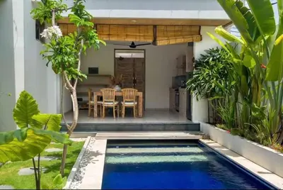 a swimming pool in a backyard with a table and chairs at Villa Catta Seminyak in Legian