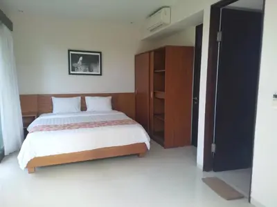 a bedroom with a bed and a wooden cabinet at Seminyak Apartment by LBV in Seminyak