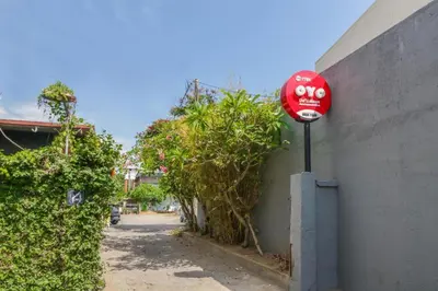 a red stop sign on the side of a building at OYO 1755 De'balcon Accomodation Near Ngurah Rai Airport in Ngurah Rai International Airport