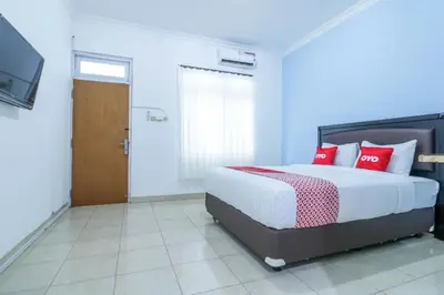 a bedroom with a large bed with red pillows at OYO 1755 De'balcon Accomodation Near Ngurah Rai Airport in Ngurah Rai International Airport