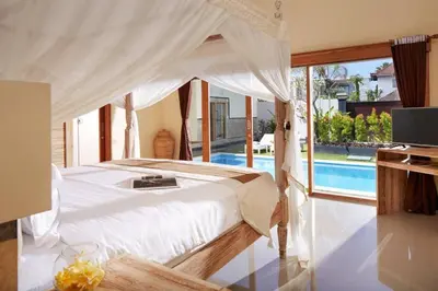 a bedroom with a bed and a swimming pool at Sol Bella Villa 3 in Seminyak