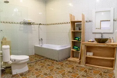 a bathroom with a tub and a toilet and a sink at Sol Bella Villa 3 in Seminyak