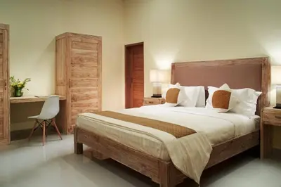 a bedroom with a large bed and a desk at Sol Bella Villa 3 in Seminyak
