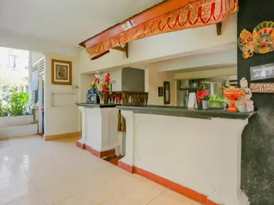 a kitchen with a counter with flowers on it at Hotel O Ari Beach Inn in Legian