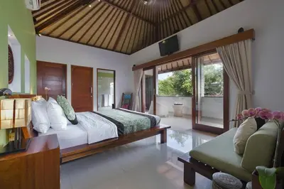 a bedroom with a large bed and a couch at ViLLA GREEN MANGGO III in Seminyak