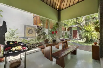 a living room with a table and a bench at ViLLA GREEN MANGGO III in Seminyak