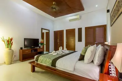 a bedroom with a large bed and a tv at ViLLA GREEN MANGGO III in Seminyak