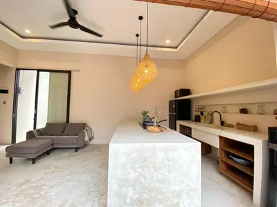 a kitchen and living room with a ceiling fan at Luminara villa in Canggu