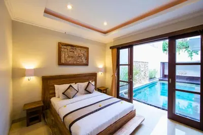 a bedroom with a bed and a swimming pool at Divija 2 BR Private Pool Villa in Seminyak