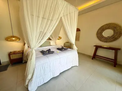 a bedroom with a white bed with a canopy at Villa NANEE - Legian - 5 Bedroom - 5 Bathroom in Legian