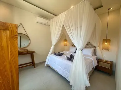 a bedroom with a white bed with a canopy at Villa NANEE - Legian - 5 Bedroom - 5 Bathroom in Legian