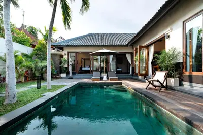 a swimming pool in the backyard of a villa at Villa Damira in Seminyak