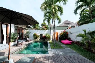 a backyard with a swimming pool and an umbrella at Villa Damira in Seminyak